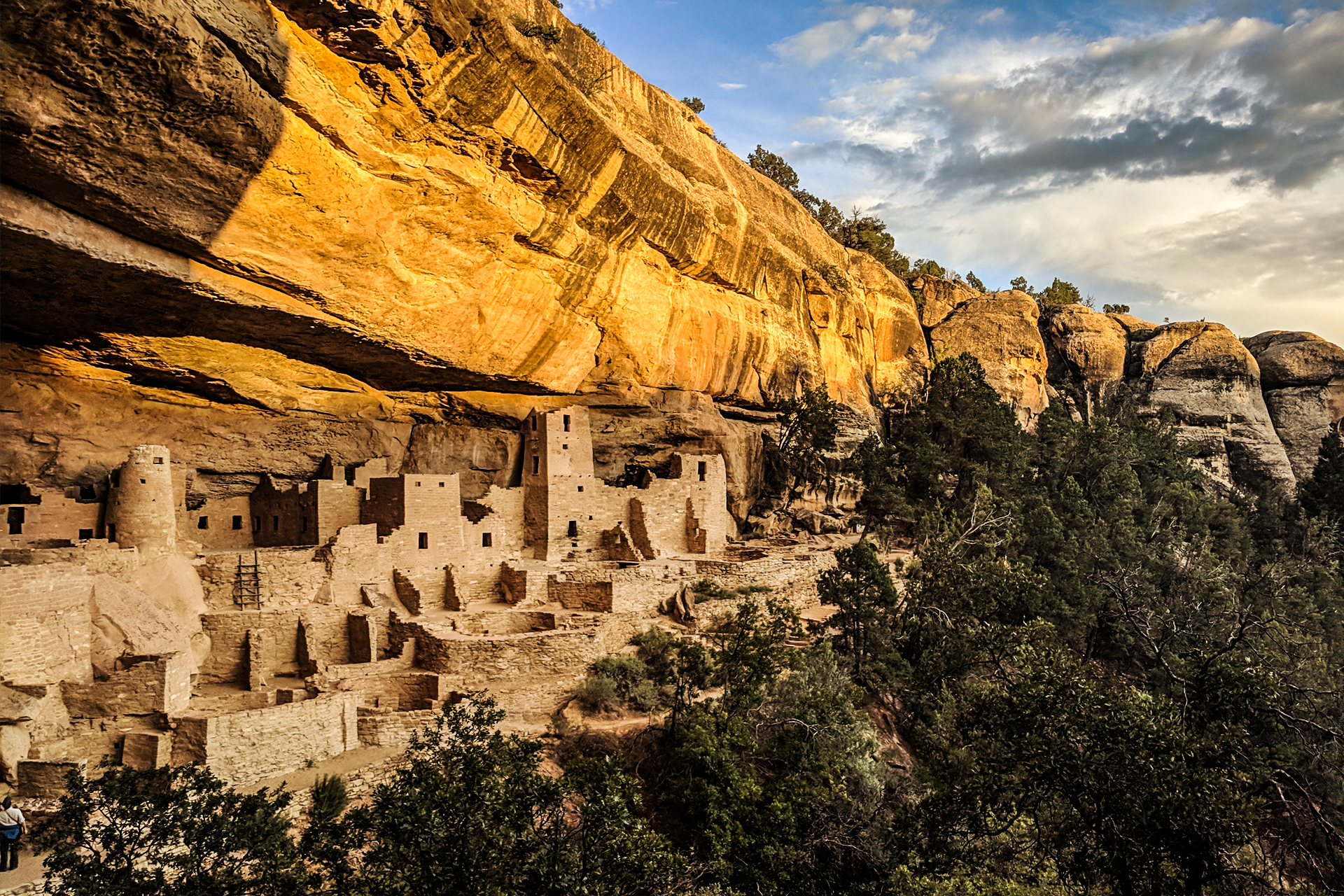An image of Cliff Palace at sunset with golden light.